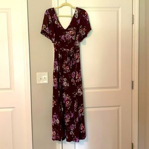 A maroon dress with flowers on it and a tie